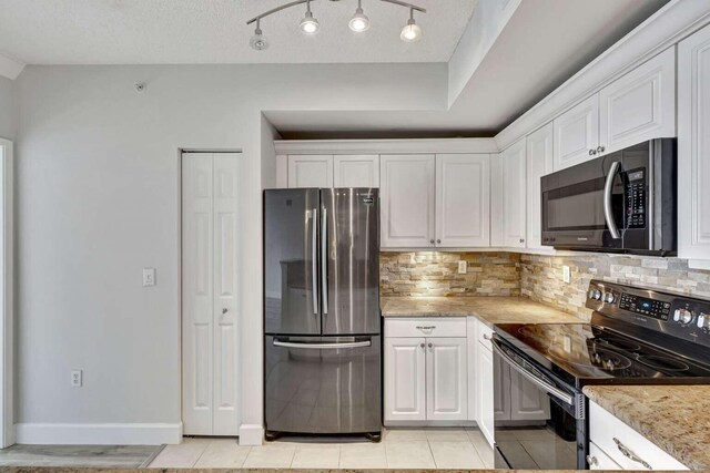 kitchen featuring white cabinets, appliances with stainless steel finishes, and light stone countertops