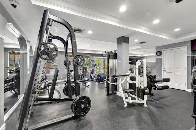 gym with crown molding and a tray ceiling