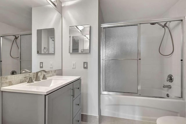 full bathroom featuring toilet, combined bath / shower with glass door, and vanity