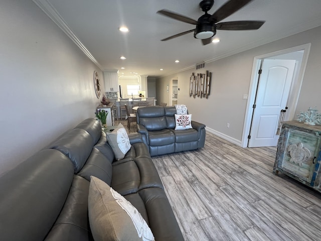 living area featuring recessed lighting, visible vents, baseboards, ornamental molding, and light wood-type flooring