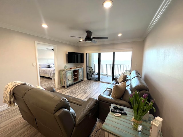 living room with light hardwood / wood-style floors, ornamental molding, and ceiling fan