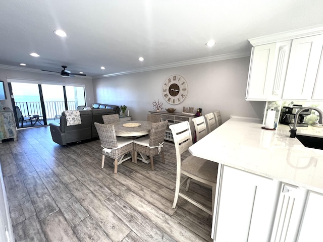 dining area featuring a ceiling fan, recessed lighting, crown molding, and wood finished floors