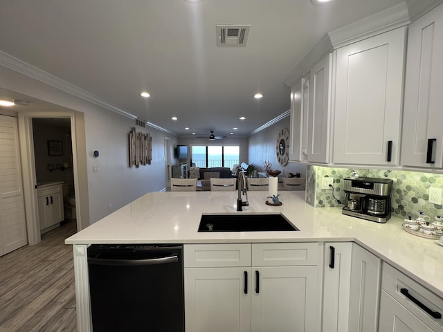 kitchen with a sink, crown molding, a peninsula, and dishwasher