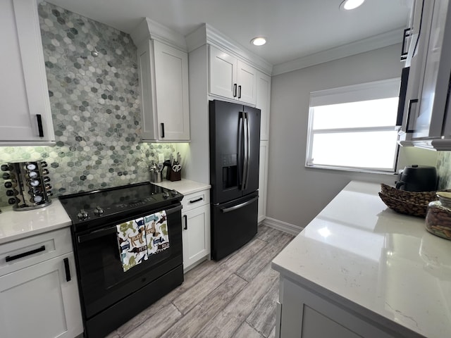 kitchen featuring light wood-style flooring, decorative backsplash, ornamental molding, white cabinetry, and black appliances