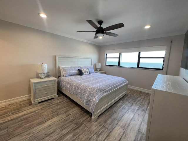 bedroom featuring ceiling fan, wood-type flooring, and ornamental molding