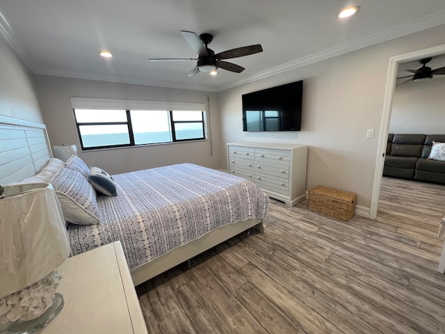 bedroom featuring ceiling fan, hardwood / wood-style floors, and ornamental molding