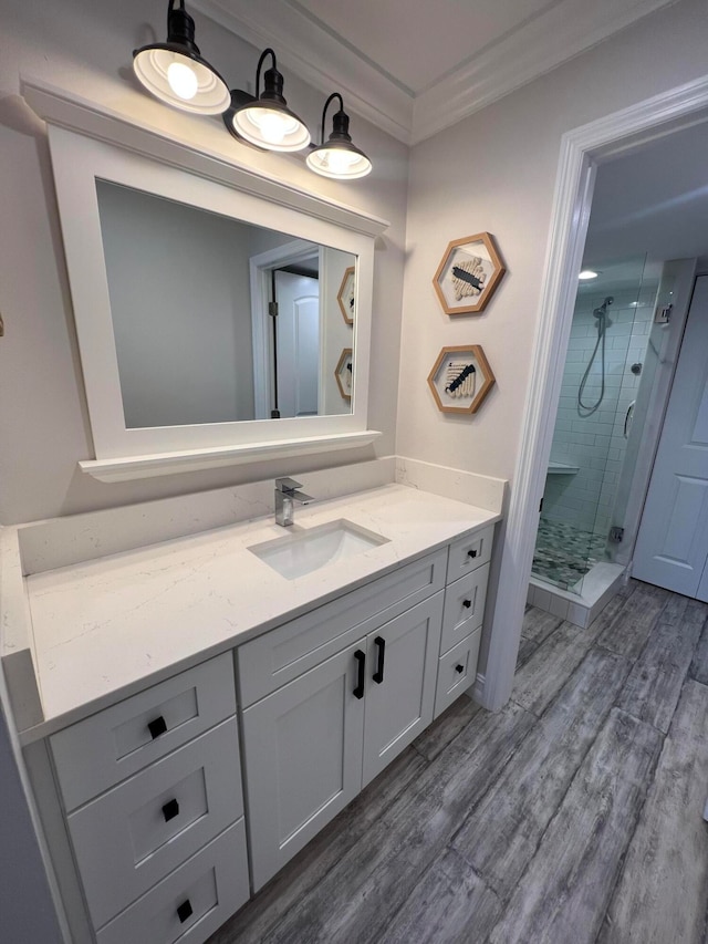 bathroom featuring a shower with door, crown molding, vanity, and hardwood / wood-style flooring