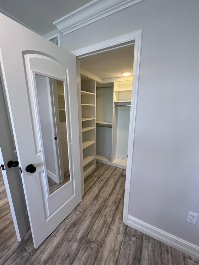 spacious closet featuring wood finished floors and visible vents