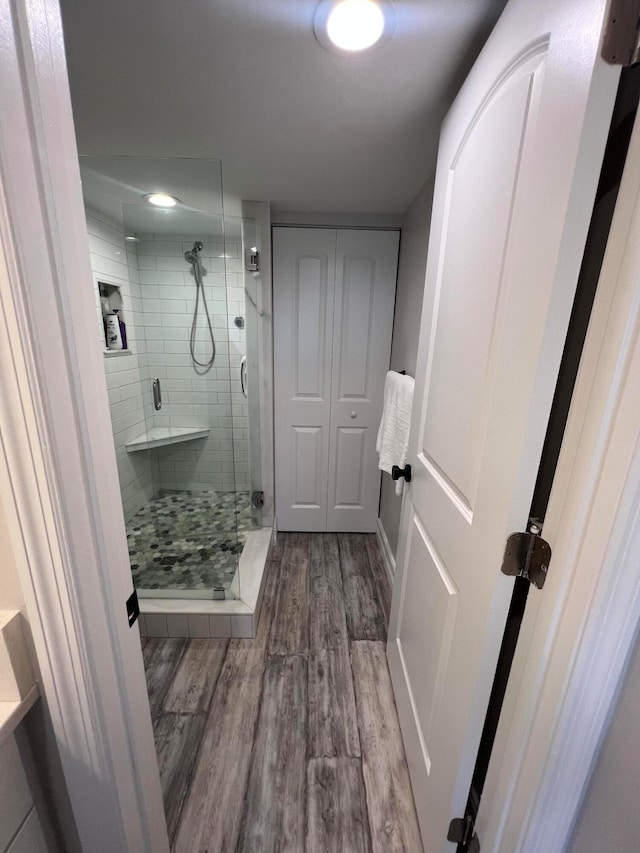 bathroom featuring a shower with door and hardwood / wood-style floors