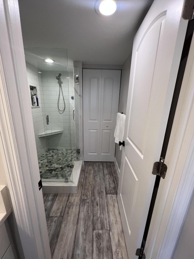 full bath with a stall shower and wood finished floors