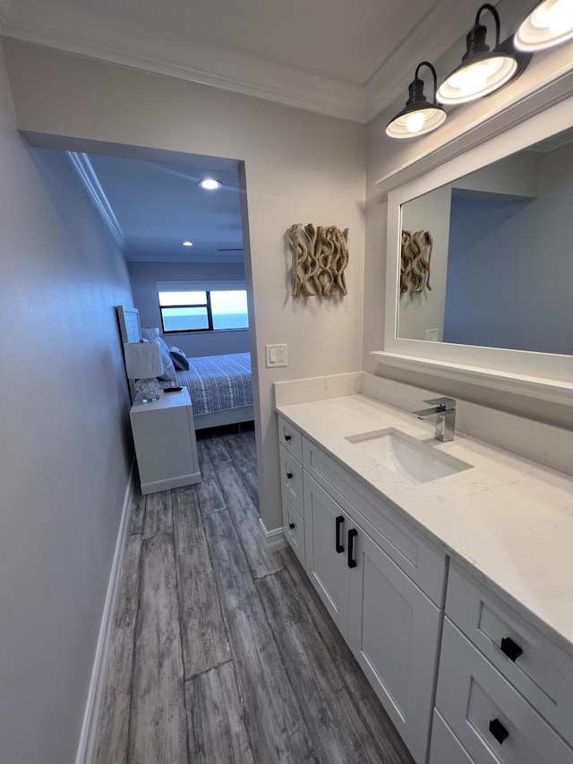 ensuite bathroom featuring baseboards, ensuite bath, wood finished floors, and crown molding