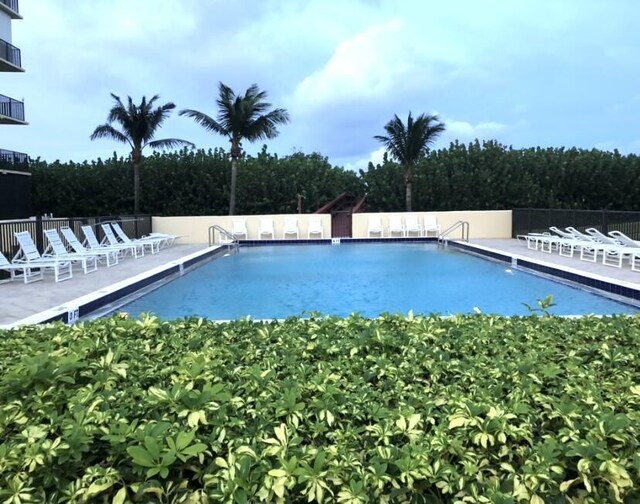 pool with a patio area and fence