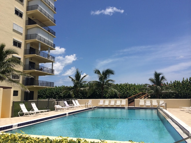 community pool featuring fence and a patio