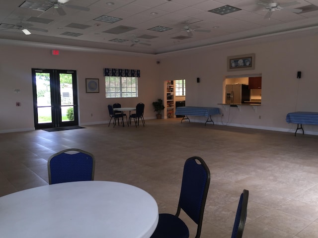 dining space with a ceiling fan, a raised ceiling, a drop ceiling, and baseboards