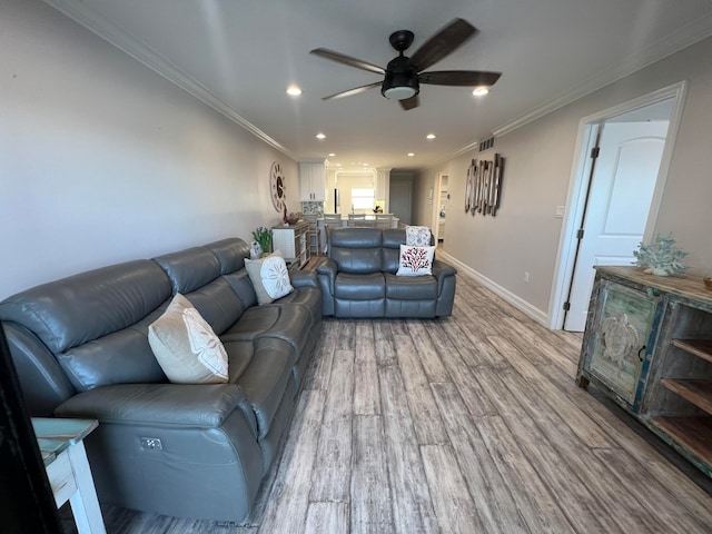 living room with ceiling fan, light wood-type flooring, and ornamental molding