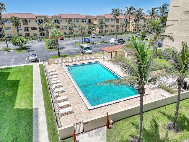 pool featuring a residential view, fence, and a lawn