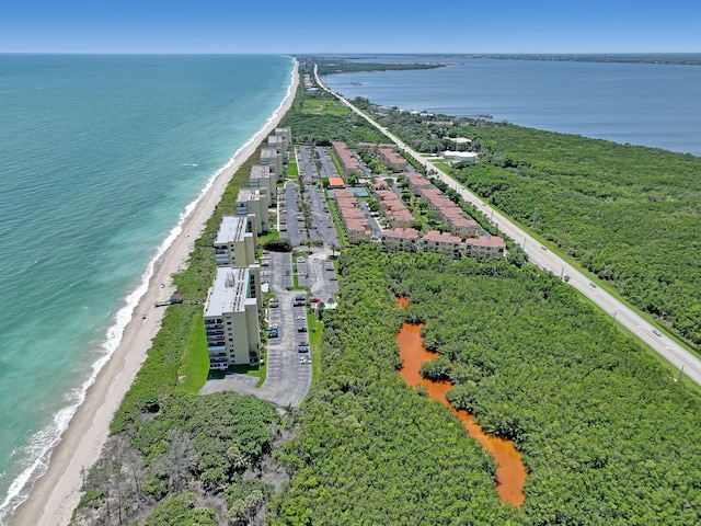 drone / aerial view featuring a beach view and a water view