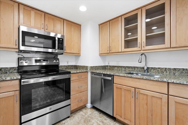 kitchen featuring light tile patterned flooring, stainless steel appliances, light brown cabinetry, stone countertops, and sink