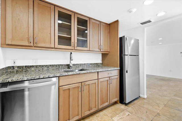 kitchen featuring light tile patterned flooring, sink, light stone counters, and stainless steel appliances