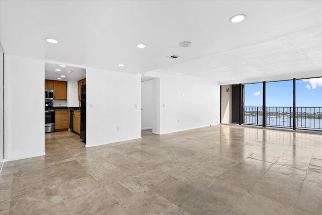 tiled empty room featuring expansive windows