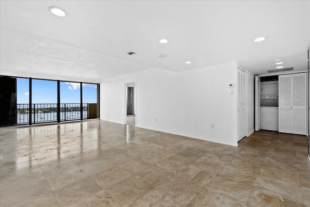 spare room featuring a wall of windows and light tile patterned floors