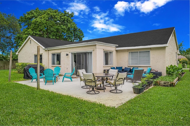 back of property with outdoor lounge area, a patio area, and a lawn