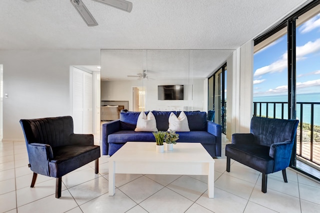 living room featuring a textured ceiling, ceiling fan, and light tile patterned floors