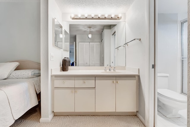 bathroom featuring tile patterned flooring, toilet, vanity, and a textured ceiling