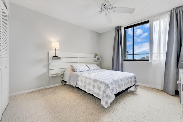 bedroom featuring light carpet, ceiling fan, and a closet