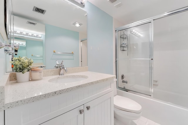 full bathroom with bath / shower combo with glass door, tile patterned floors, toilet, and vanity