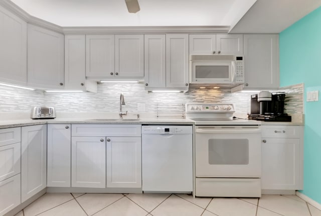 kitchen featuring tasteful backsplash, white appliances, sink, light tile patterned flooring, and white cabinetry