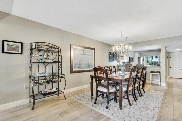 dining space featuring light hardwood / wood-style flooring and a chandelier