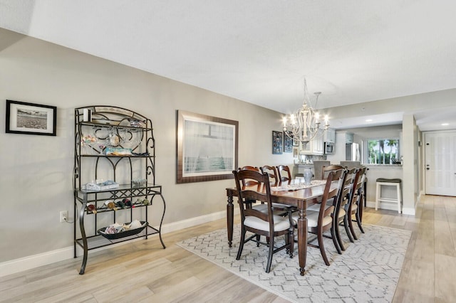 dining room featuring a notable chandelier and light wood-type flooring