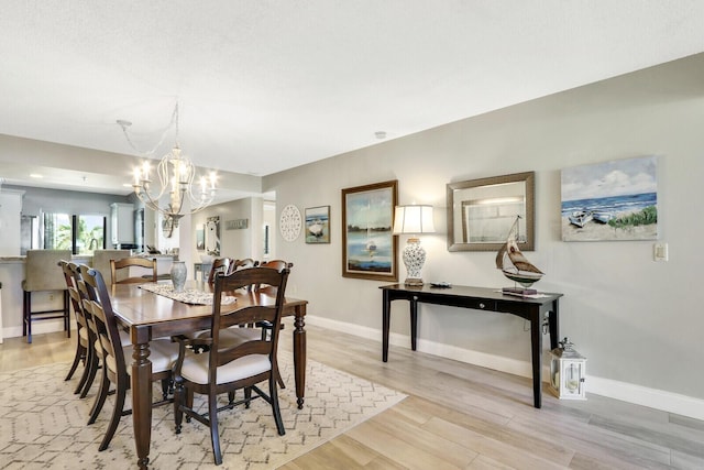 dining room with a notable chandelier and light hardwood / wood-style flooring