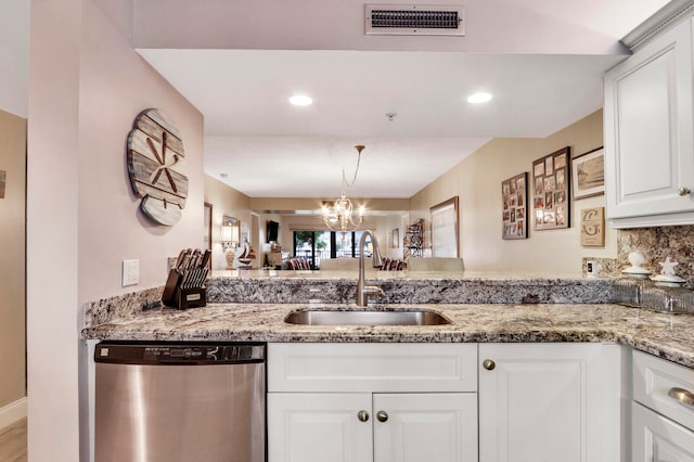 kitchen featuring sink, dishwasher, kitchen peninsula, and light stone countertops