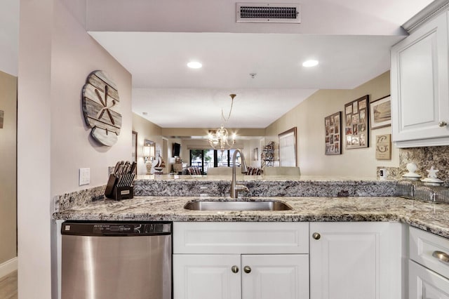 kitchen with sink, dishwasher, light stone counters, a notable chandelier, and white cabinets