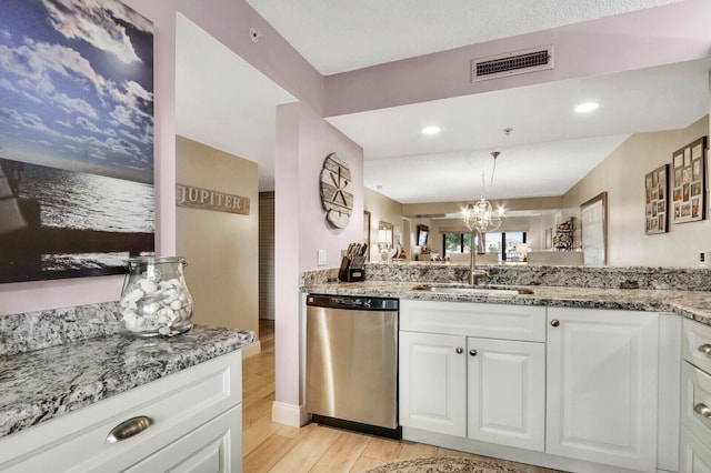 kitchen with white cabinets, sink, stainless steel dishwasher, light hardwood / wood-style floors, and light stone counters