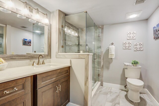 bathroom featuring toilet, tile patterned floors, vanity, and a shower with shower door