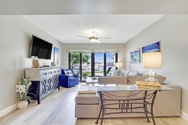 living room with hardwood / wood-style floors, a textured ceiling, and ceiling fan