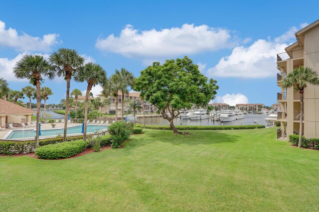 view of yard with a community pool and a water view