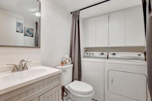 bathroom with vanity, independent washer and dryer, and toilet