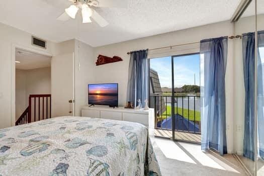 bedroom featuring light carpet, access to outside, and ceiling fan