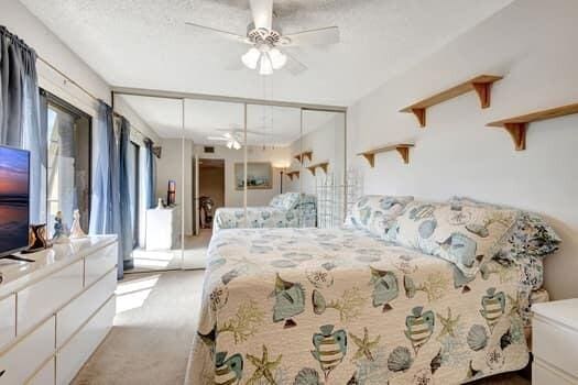 carpeted bedroom featuring a closet and ceiling fan