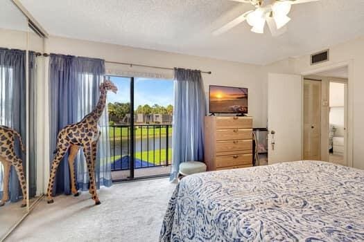 carpeted bedroom featuring ceiling fan and access to exterior