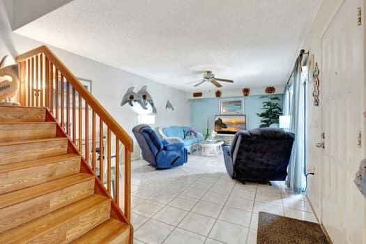 living room with light tile patterned flooring and ceiling fan