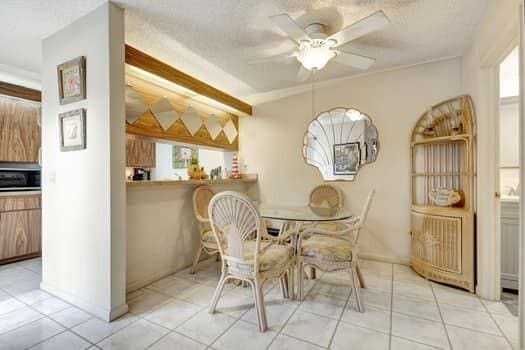 tiled dining space featuring ceiling fan