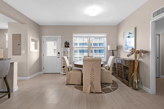 dining area with electric panel and light hardwood / wood-style floors