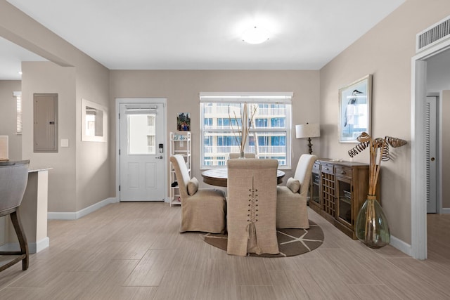 dining area with visible vents, light wood-type flooring, electric panel, and baseboards