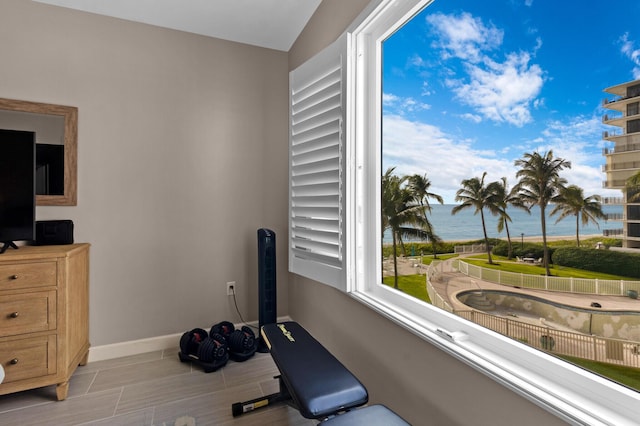 exercise area with a water view and baseboards