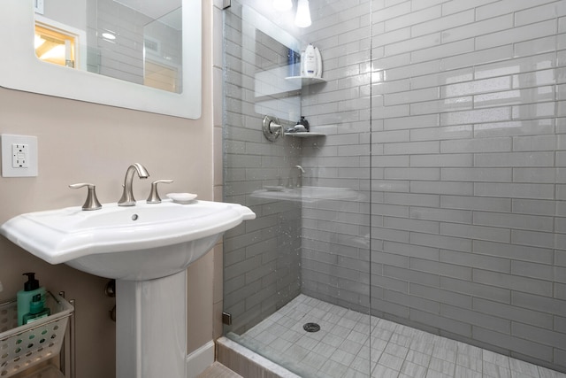 bathroom with a shower with door and sink